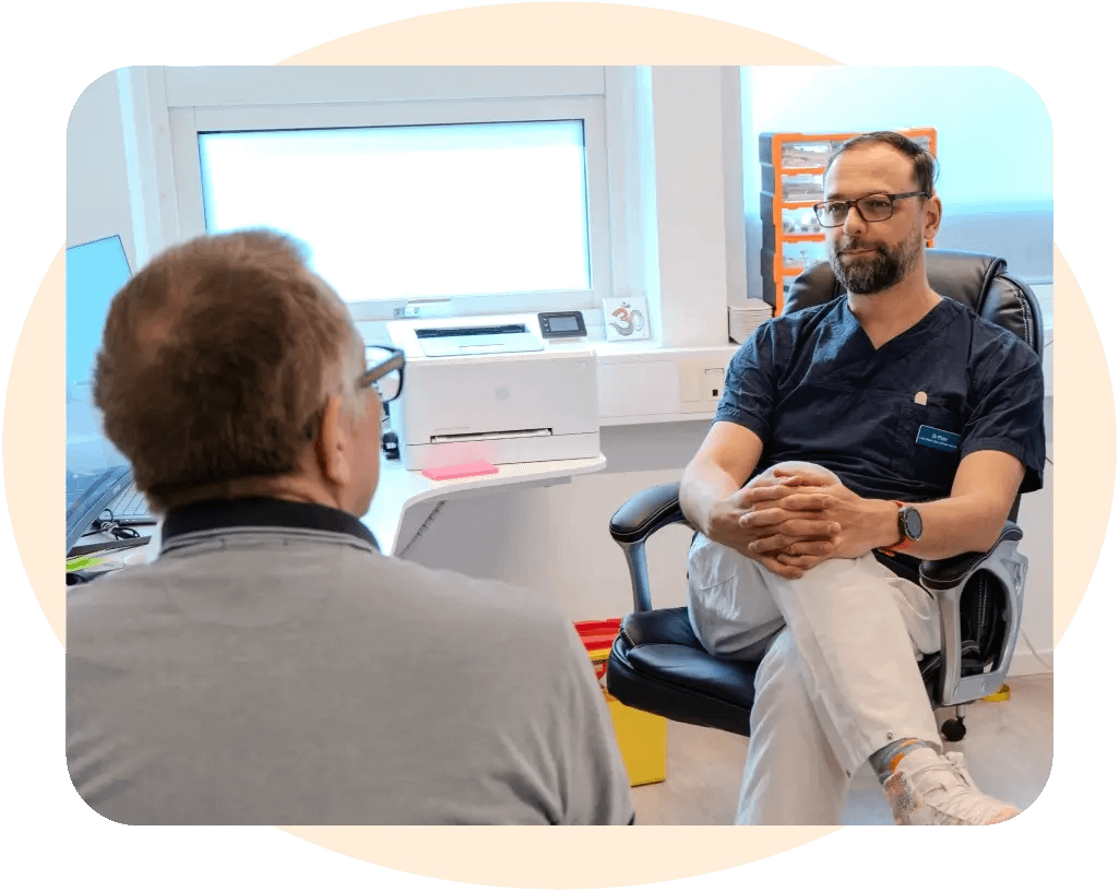 En läkare sitter och lyssnar på en patient
